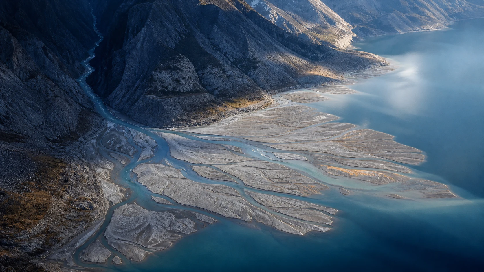 One alpine river channel opens into a broad braided delta.