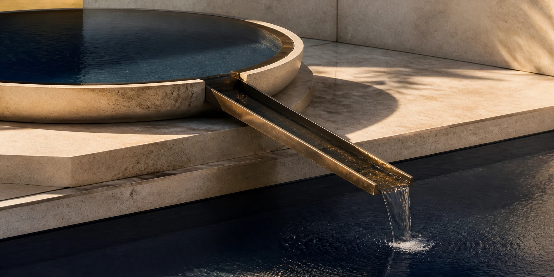 A precise bronze channel moves water between two balanced stone basins.