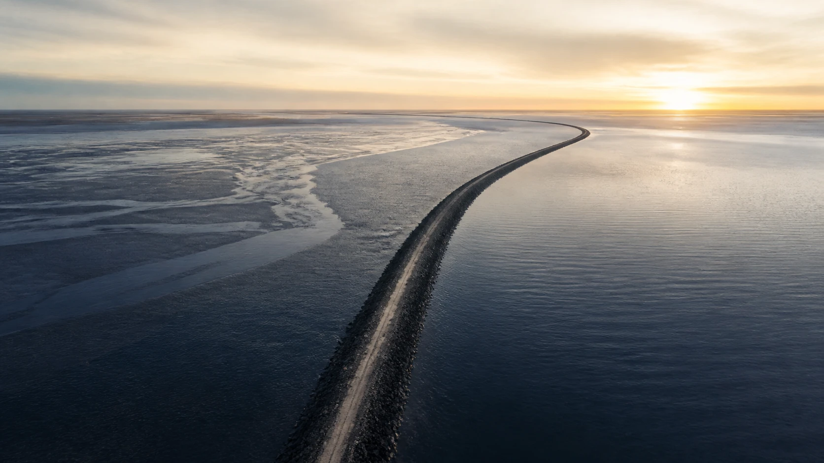 A precise charcoal-stone causeway organizes two calm currents before opening toward the horizon.