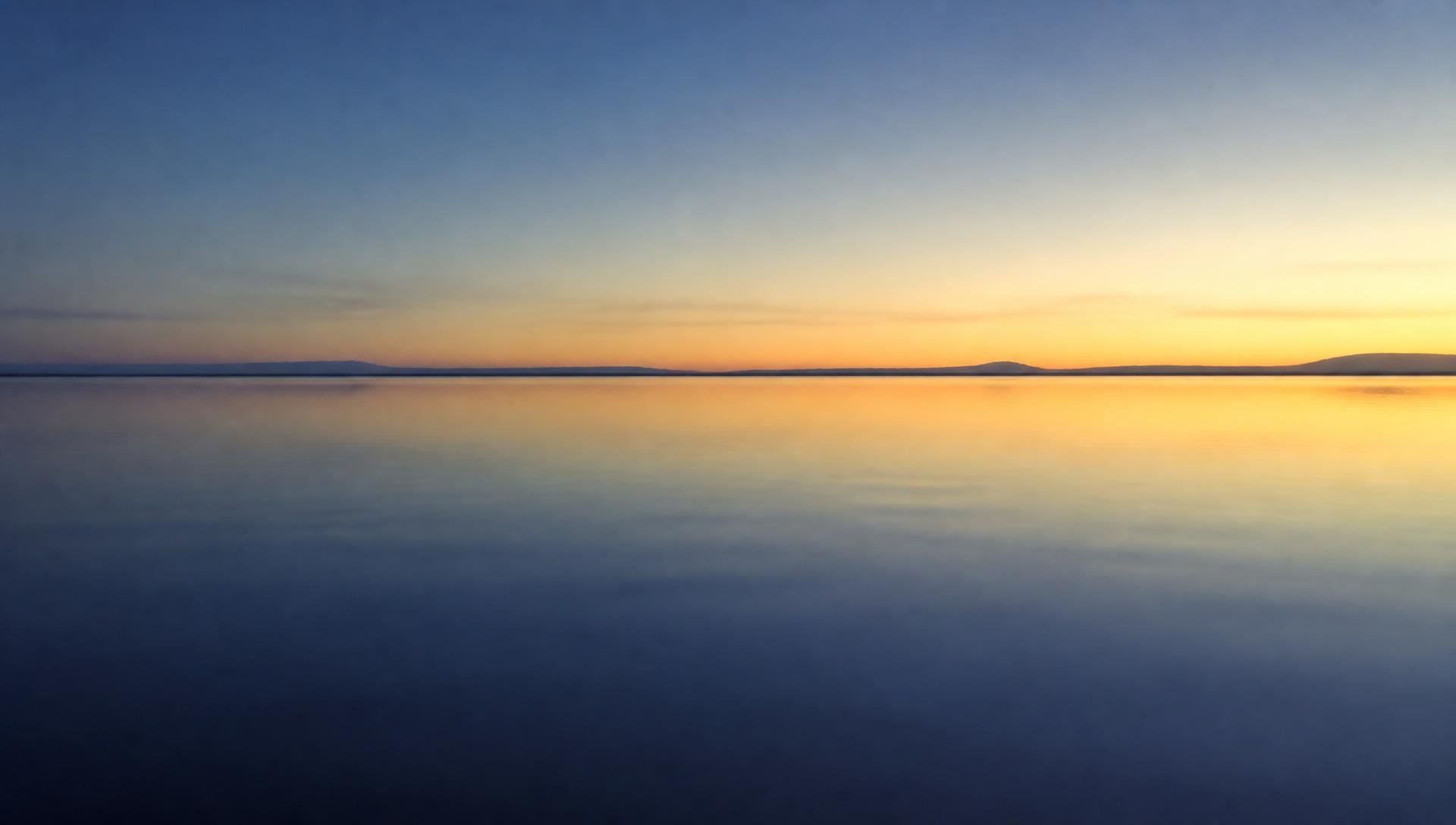 Open still water under a wide horizon